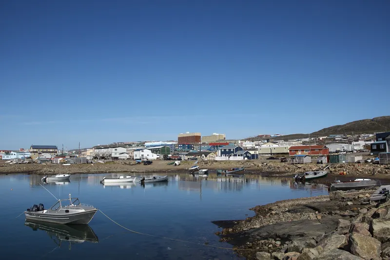 Waterfront of Iqaluit with fisher boats in the foreground and the cityscape of the town in the background