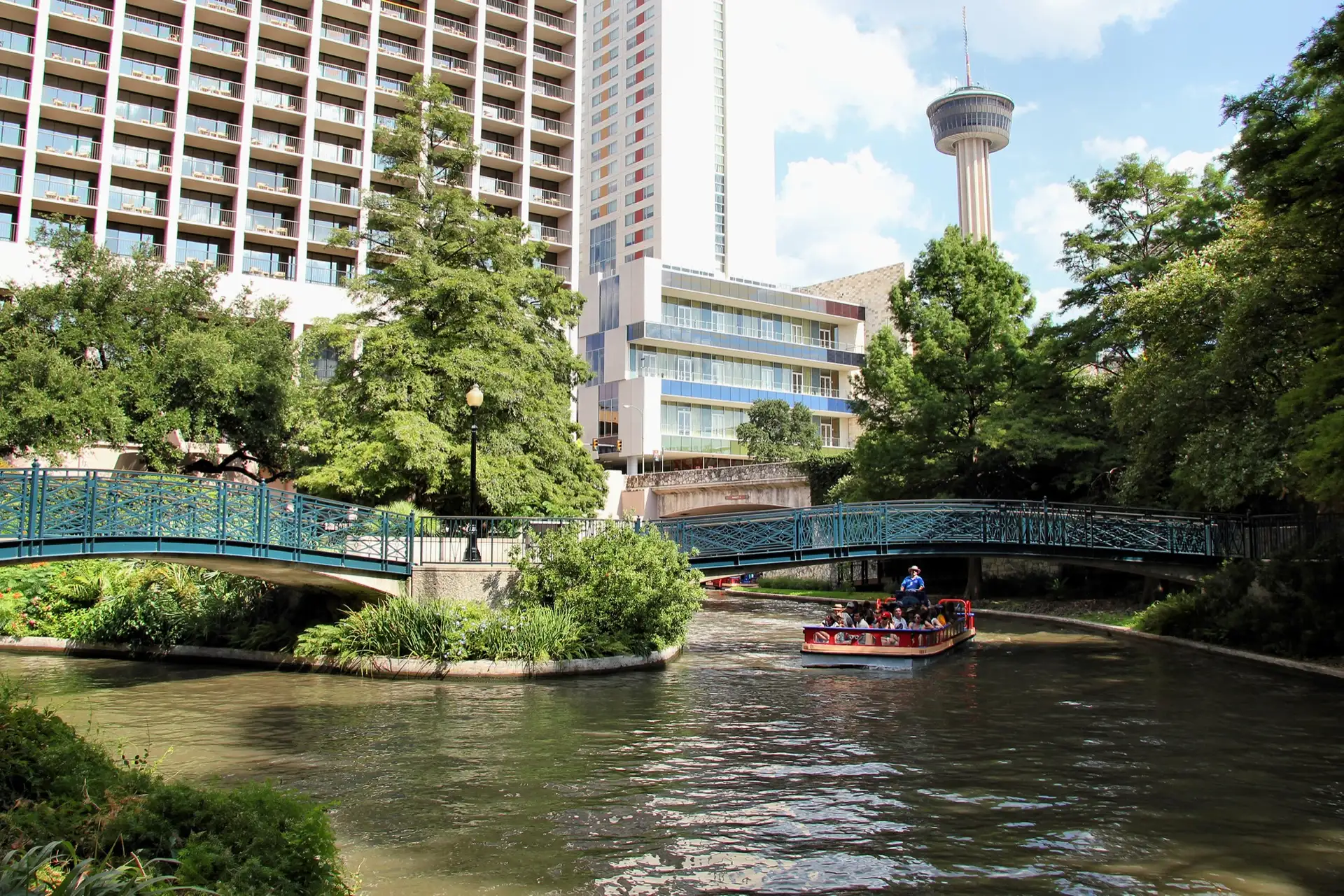 The San Antonio River Walk with the Tower of the Americas in the background in San Antonio, Texas, United States.